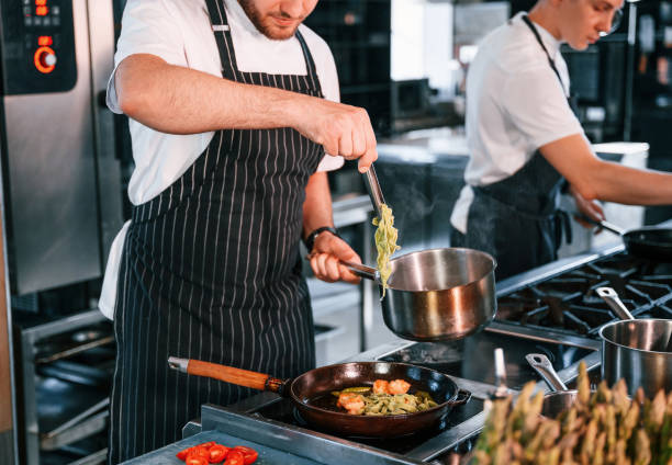 istock Frying the meat. Kitchen workers is together preparing the food 1419075775
