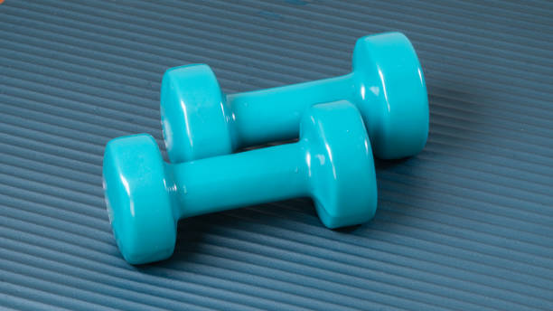 istock Two blue dumbbells on the workout mat - sports background 1419076585