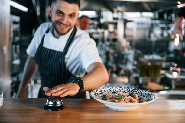 istock Order is complete. Kitchen workers is together preparing the food 1419076629
