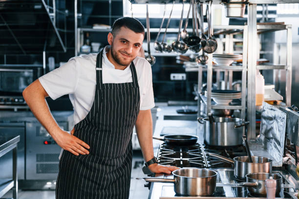 istock Standing and smiling. Chef is on the kitchen preparing food 1419076637