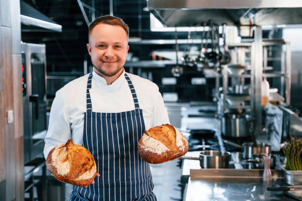 istock Holding fresh bread. Chef is on the kitchen preparing food 1419076678
