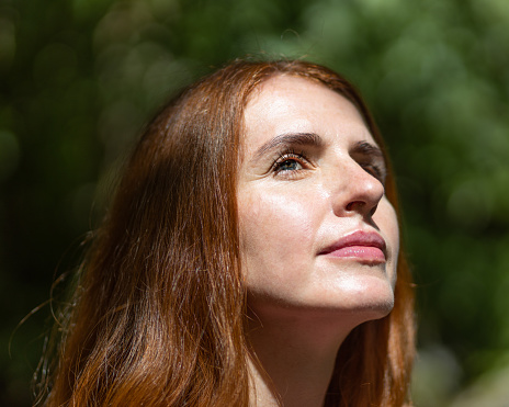 Close-up portrait of a mature light-eyed red-haired beautiful middle-aged woman. High quality photo