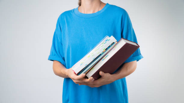 istock A female student with a stack of books and notebooks for classes 1419077170