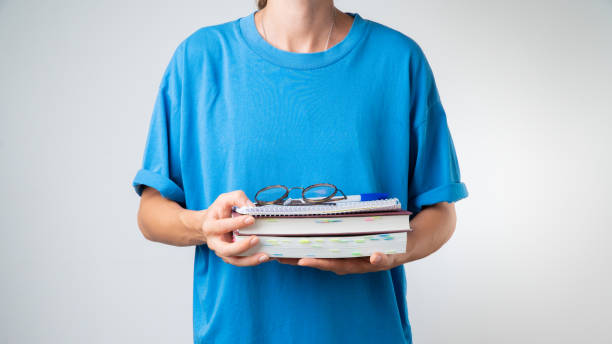 istock A female student with a stack of books and notebooks for classes 1419077492