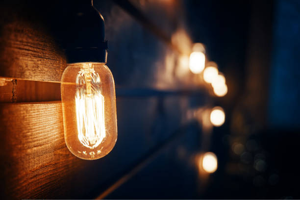 istock Antique incandescent Edison type bulb on wooden wall. 1419078953