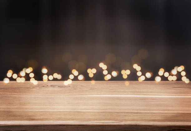 istock Christmas background with defocused lights and dark empty wood table. 1419079304