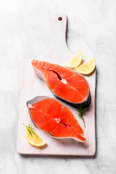 Raw salmon fish steak Raw salmon fish steak ready for cook on white marble background background. Uncooked salmon pieces - healthy food ingredient. sockeye salmon filet stock pictures, royalty-free photos & images