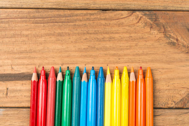 Concept of back to school. Marker pens and colored pencils on wooden boards.