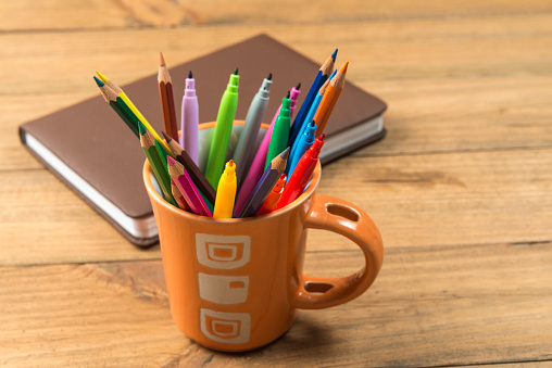 Concept of back to school. Cup full of markers and colored pencils.
