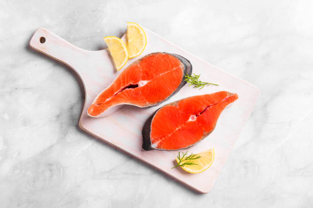 Raw salmon fish steak Raw salmon fish steak ready for cook on white marble background background, copy space. Uncooked salmon pieces - healthy food ingredient. sockeye salmon filet stock pictures, royalty-free photos & images