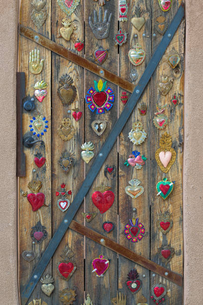 Chinchon, Spain - July 16 2021: Detail of golden decor in wooden green door in the shape of Jesus Christ with sacred heart