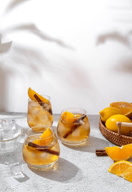 brillante ponche navideño. tres vasos de brillante ponche sobre fondo claro. cóctel con naranja, hielo y canela. refrescante bebida de verano. espacio libre para su texto - soft cider fotografías e imágenes de stock