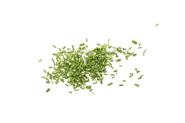 Scattered dry chive pile isolated. Dried green onion flakes, chopped dried spring onion on white background top view.