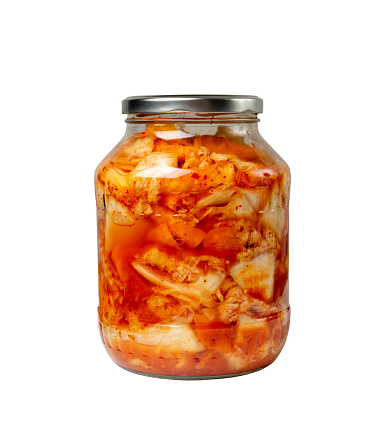 Kimchee in a glass jar isolated. Spicy kim chi, hot fermented napa cabbage, traditional jimchi, korean winter food gimchi, kimchee on white background side view