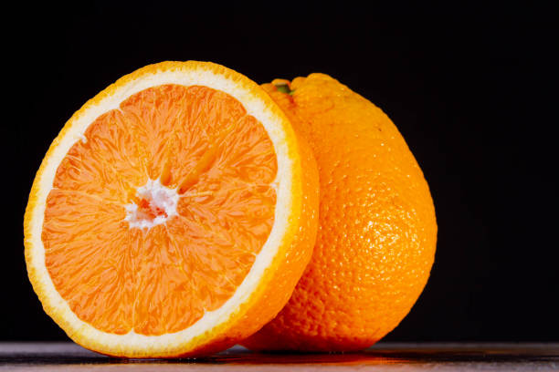 istock Half an orange. Two halves of fruit on a wooden table. Copyspace. 1419087125