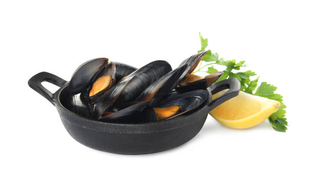 istock Pan of cooked mussels with parsley and lemon on white background 1419087516