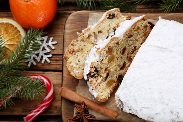 istock Traditional Christmas Stollen with icing sugar on wooden table, flat lay 1419087538