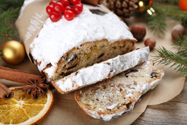 istock Traditional Christmas Stollen with icing sugar and cranberries on wooden table, closeup 1419087568