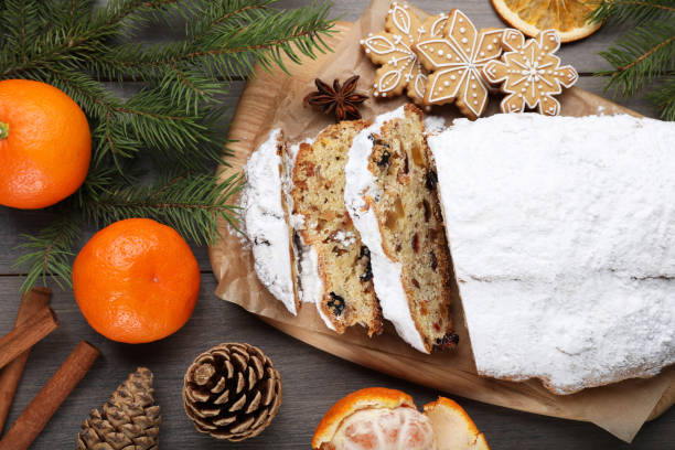 istock Traditional Christmas Stollen with icing sugar on wooden table, flat lay 1419087657