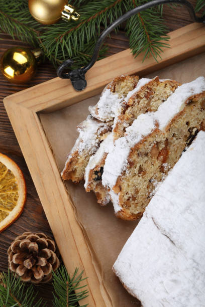 istock Traditional Christmas Stollen with icing sugar on wooden table, flat lay 1419088482