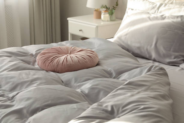 istock Bed with stylish silky linens in room 1419090644
