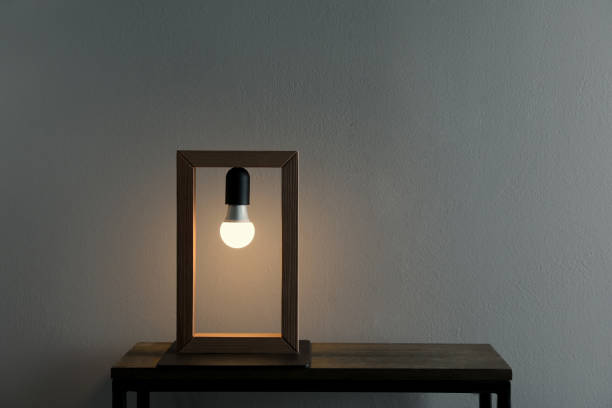 istock Wooden table with modern lamp near grey wall in room, space for text 1419090858