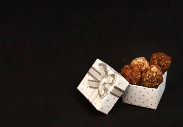 Truffle candies in a white box. Sweet chocolate gift. The temptation of sweet food.