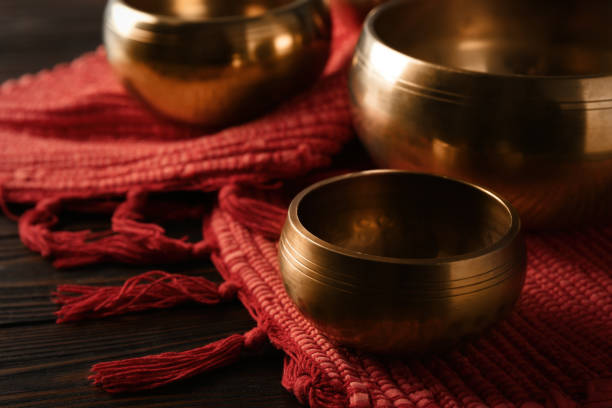 istock Tibetan singing bowls and red fabric on wooden table 1419091704