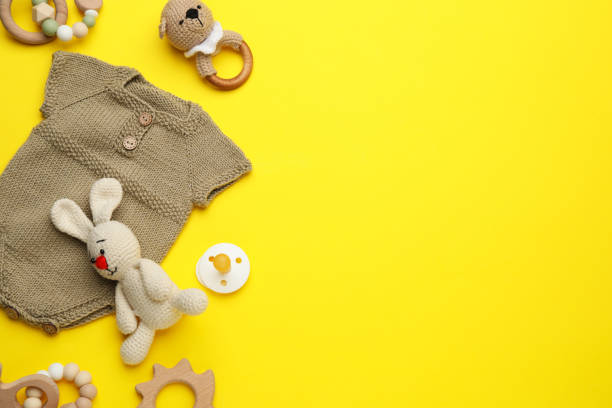 istock Baby clothes and accessories on yellow background, flat lay. Space for text 1419091767