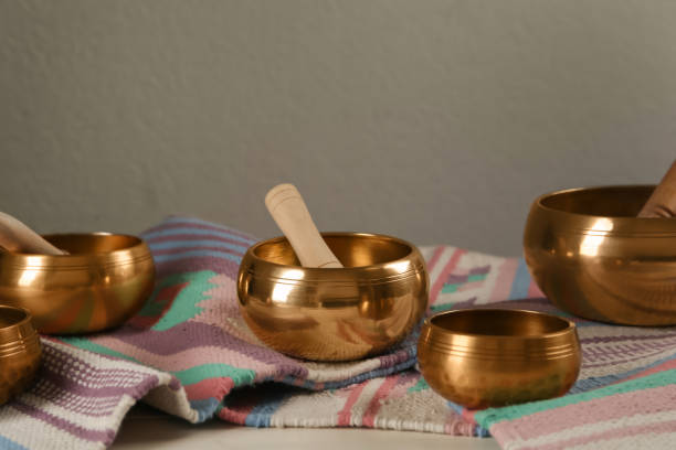 istock Tibetan singing bowls with mallets and colorful fabric on white table 1419092011