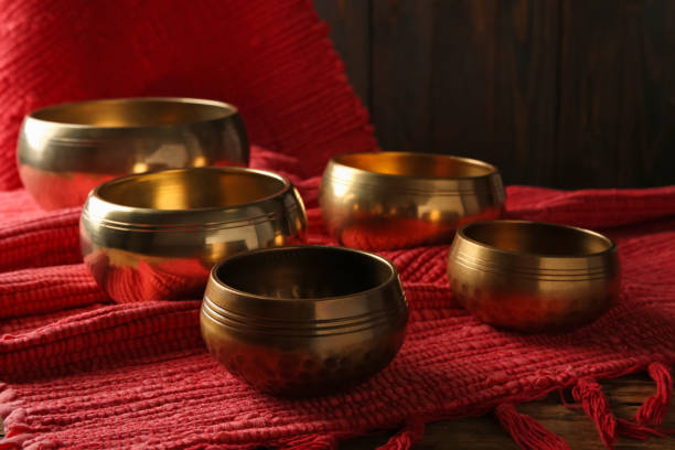 istock Tibetan singing bowls and red fabric on wooden table 1419092012