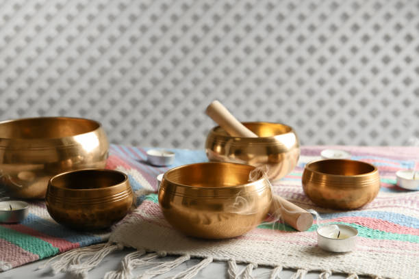 istock Tibetan singing bowls with mallets, candles and colorful fabric on white table 1419092113