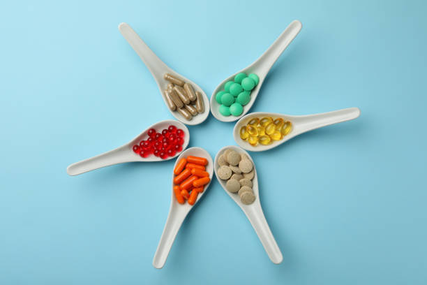 istock Spoons with different dietary supplements on light blue background, flat lay 1419092323