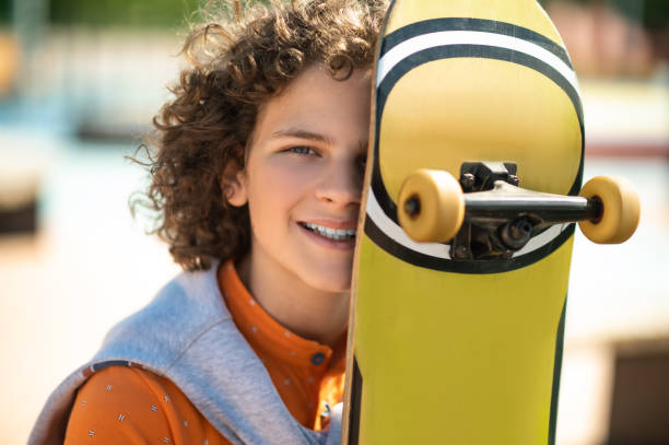 istock Joyful adolescent skateboarder with his board outdoors 1419092517