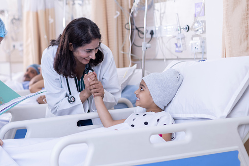 Female doctor examining little girl patient at hospital.