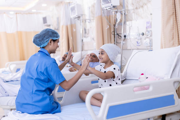 Little girl patient playing with nurse at hospital Little girl patient playing with nurse sitting on bed at hospital india hospital stock pictures, royalty-free photos & images