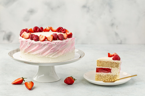 Strawberry cake, strawberry sponge cake with fresh strawberries and sour cream on a white background.