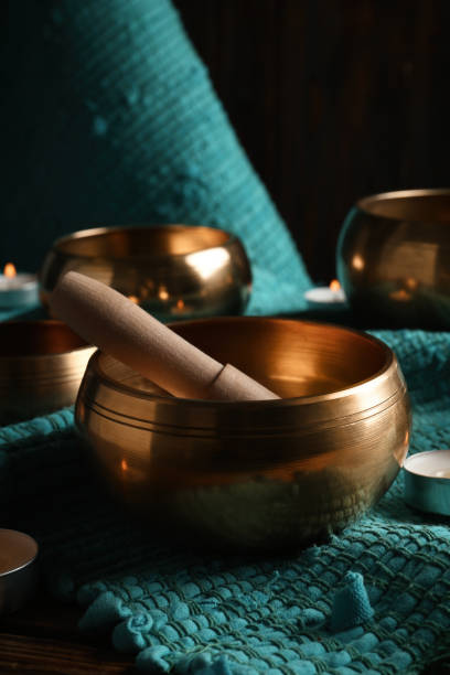 istock Tibetan singing bowls with mallet and candles on turquoise fabric 1419094486