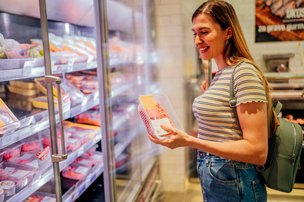 mujer en un supermercado comprando carne - supermarket meat women packaging fotografías e imágenes de stock