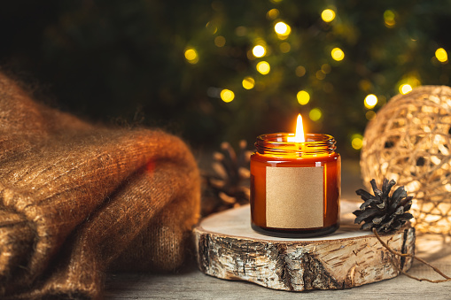 Candles lit on Christmas advent wreath with red berries and evergreen boughs, all four candles lit