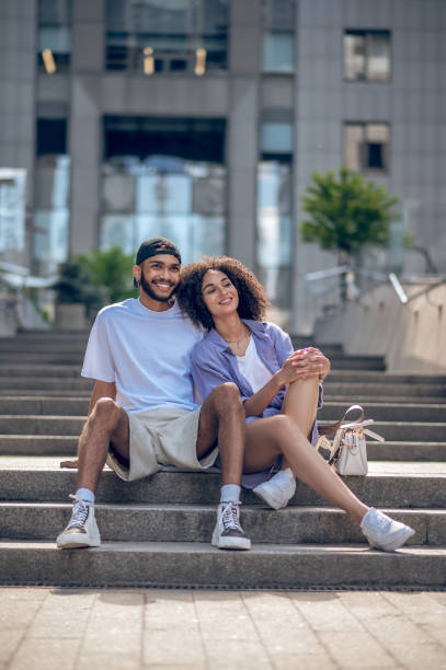 istock Young cute couple sitting on the steps and looking peaceful and happy 1419098921