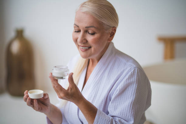 istock A woman in a white robe with a face cream 1419101095