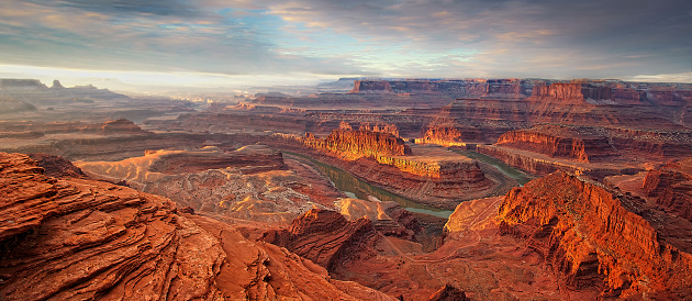 Panoramic, Sunrise from the look out view over Dead Horse Point State Park, a state park of Utah in the United States, featuring a dramatic overlook of the Colorado River and Canyonlands National Park, so named because of its use as a natural corral by cowboys in the 19th century, where horses often died of exposure