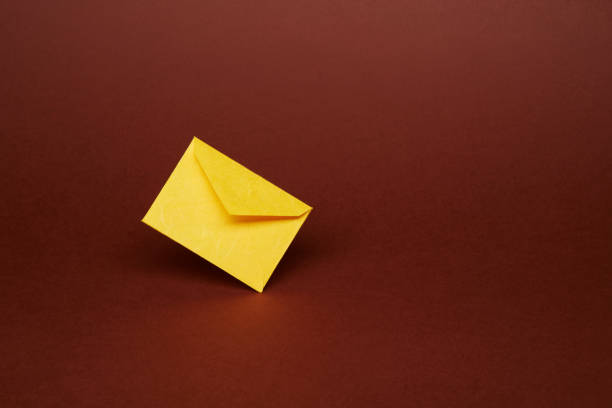 istock Yellow office envelope for greeting or invitation on the dark brown background 1419105856
