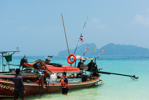 Koh Kradan Island, Krabi, Thailand. 29 March 2016. Beach on Koh Kradan Island in the Andaman Sea. Tourists coming to the island by boat tour. Traditional Thai boats and turquoise sea