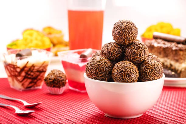 Brazilian chocolate bonbon, called Brigadeiro, made with condensed milk, chocolate powder and sprinkles, served with cake at birthday parties stock photo