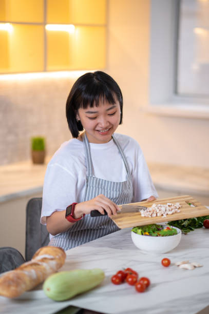 istock A woman making salad from fresh vegetables in the kitchen 1419111531