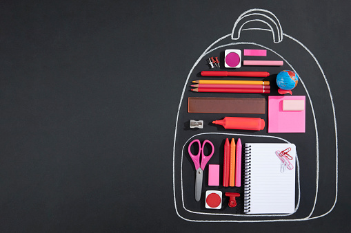 Back to school concept with chalk drawing backpack with school supplies on chalkboard