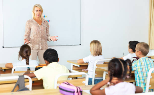 istock Woman teacher lecturing to pupils at classroom 1419112559