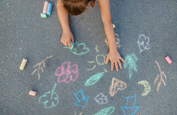 istock Girl Drawing With Chalk On Footpath 1419113397